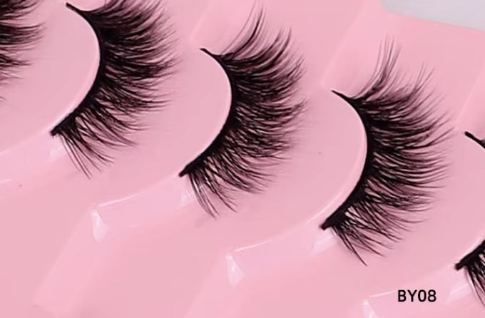 Close-up of false eyelashes arranged on a pink tray, with the text BY08 in the bottom right corner.