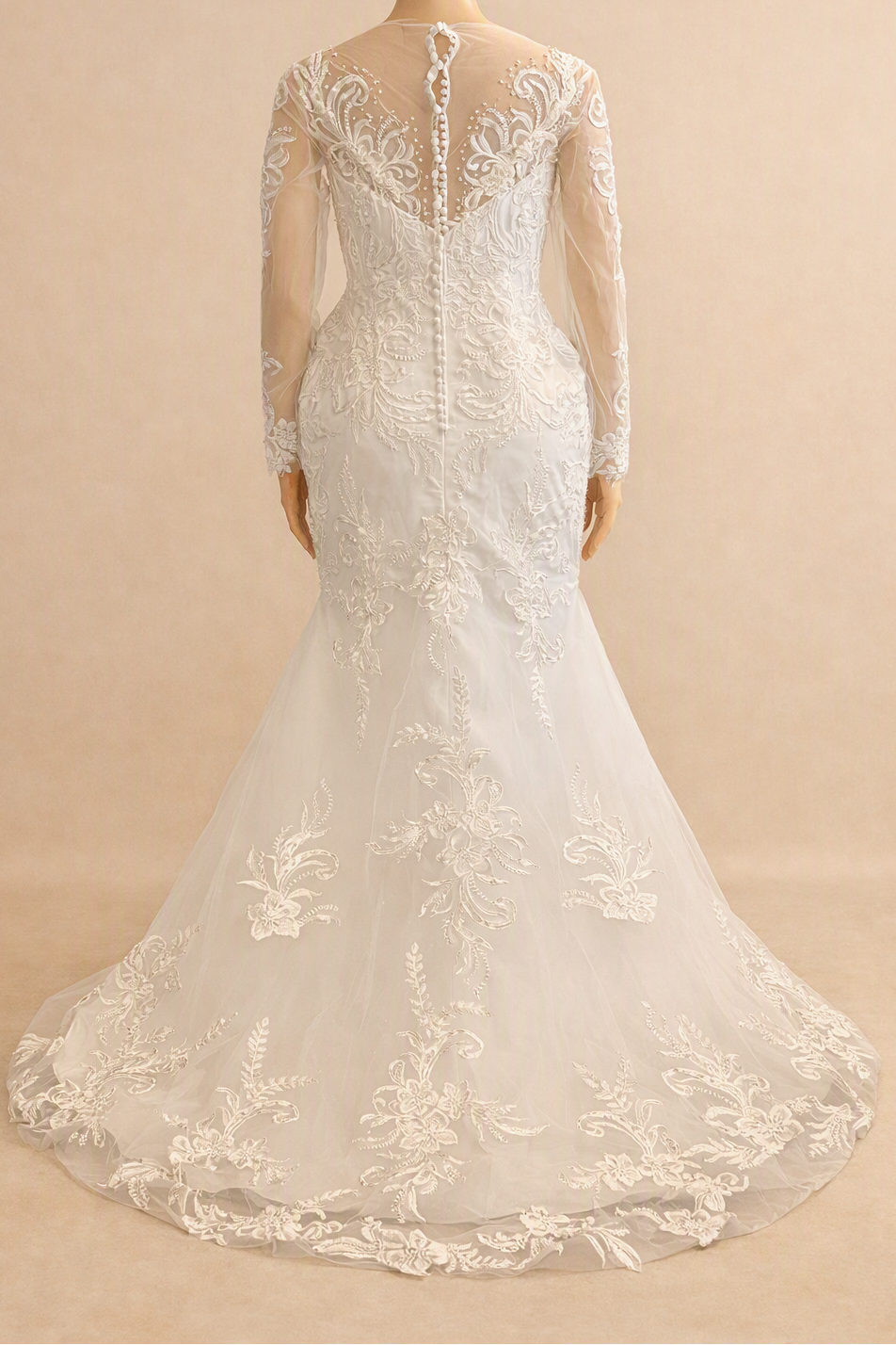  White lace mermaid bridal gown with sheer open back, button closure, and long lace sleeves, back view on mannequin