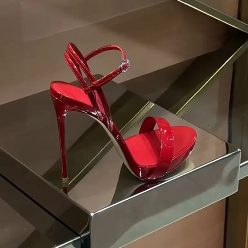 Glossy red high heels with open toe, adjustable ankle strap, and raised platform