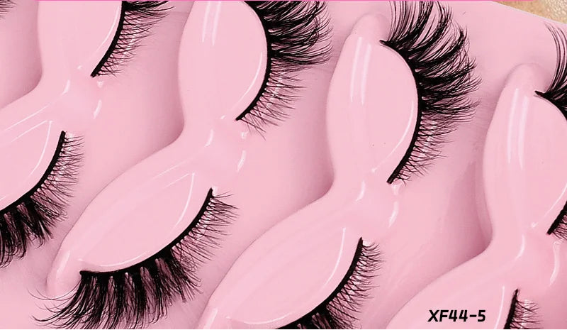 False eyelashes on a pink background with text 'Eye makeup is more attractive'.