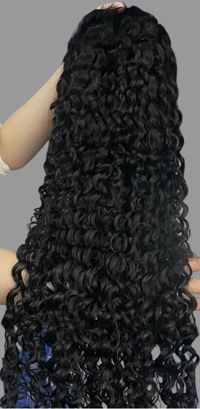 A person holds up a large bundle of long, black, water-wave curly hair extensions in front of a blue storage rack filled with plastic bags. The text 'Mona Hair/Water Wave' is displayed at the bottom.