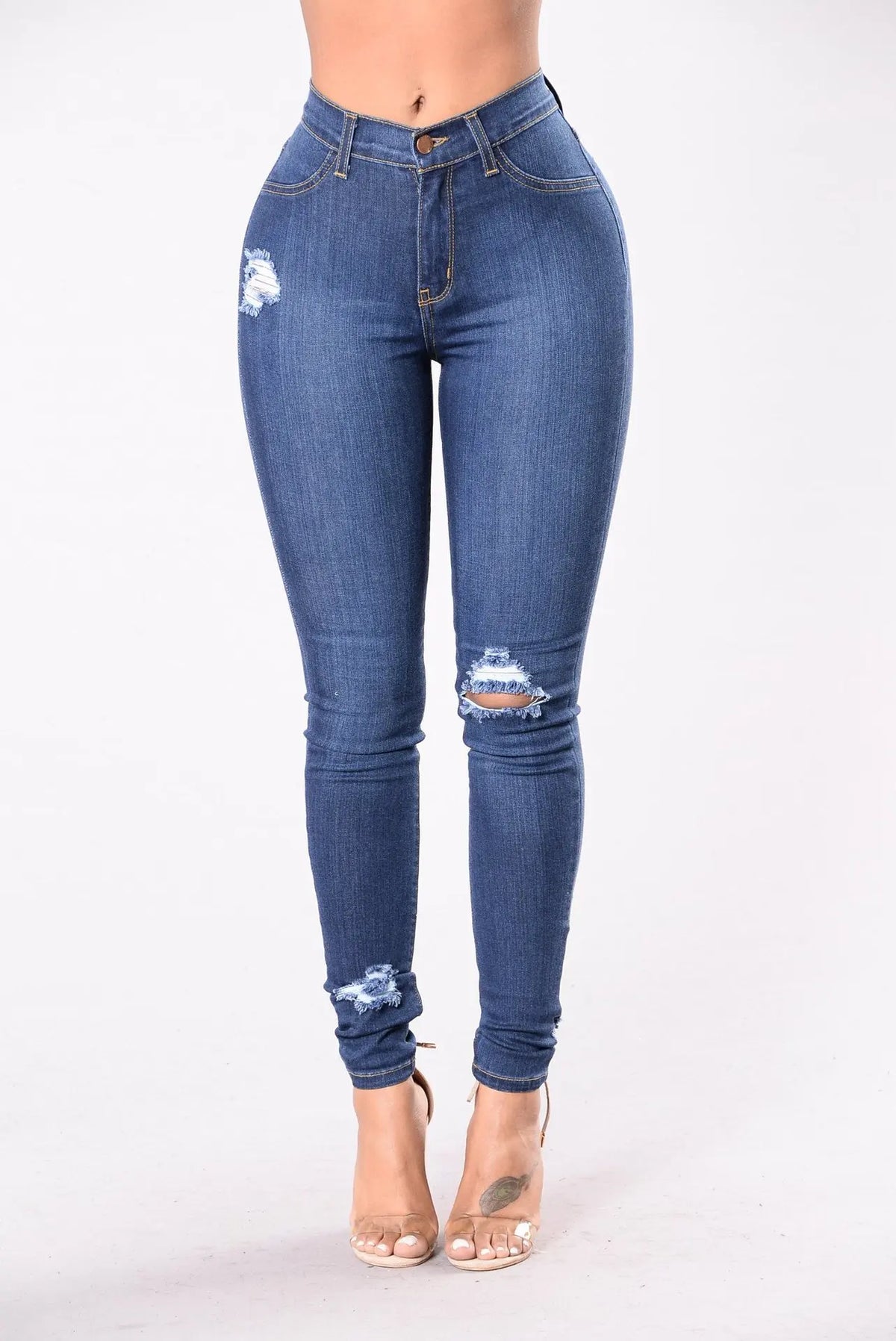 Women's light blue ripped slim denim leggings with knee and ankle distressing, front view with clear heels
