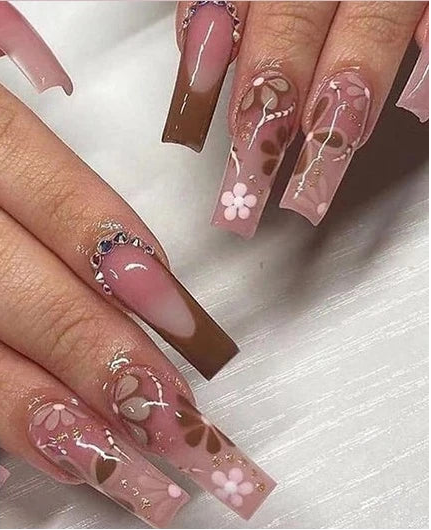A collage showing a close-up of manicured fingernails with long coffin-shaped press-on nails, plus a small inset of individual nail color options. The nails feature a glossy nude-pink to brown gradient with floral and butterfly motifs in white, pink, and brown.