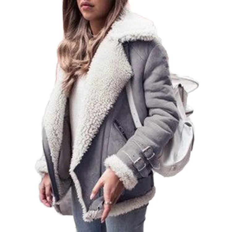 A woman wearing a gray shearling-lined aviator-style jacket with a large cream-colored collar and cuffs, paired with a white backpack, shown against a plain white background.