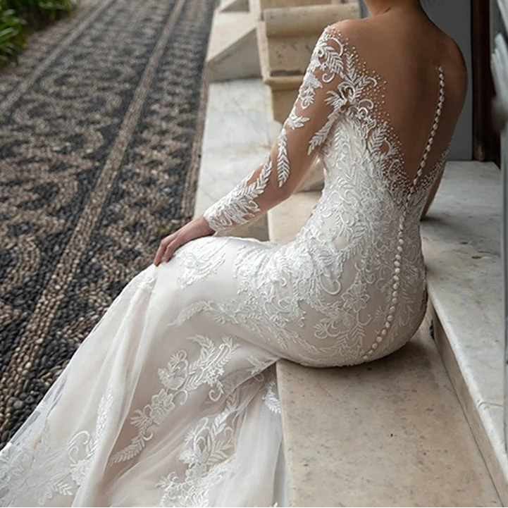 Close-up back view of lace mermaid wedding dress showing open back with button closure and floral lace appliqués