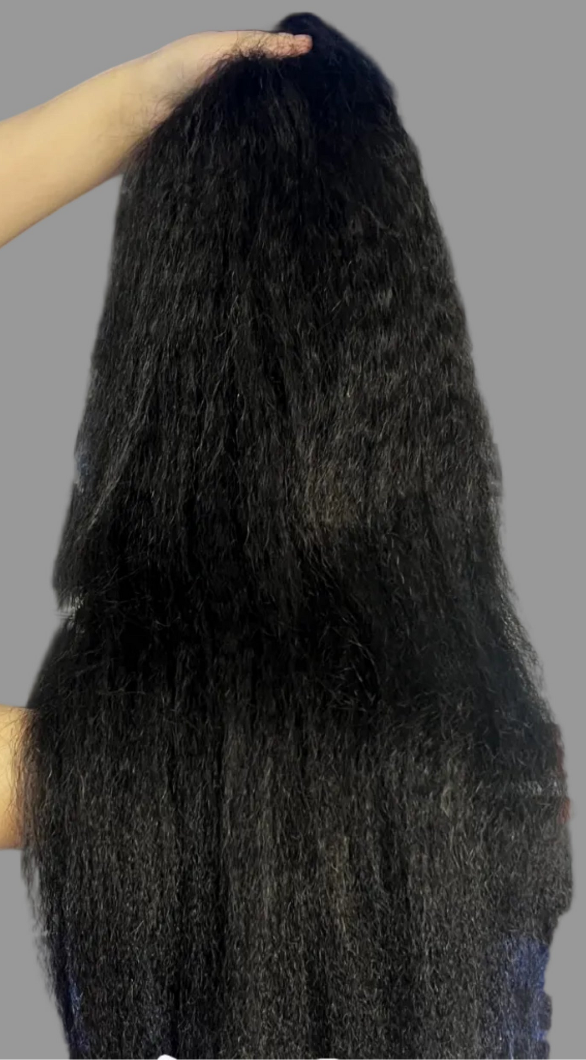 A person holds up a large bundle of very long, straight black hair extensions in front of blue storage bins and plastic bags. Text at the bottom reads 'Mona Hair/Kinky Straight'.