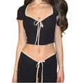 Black color block crop top and flare pants with cream tie-front detail — worn together as a set