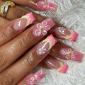 Nails with floral design on a textured white background