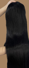 A person wearing a white knit sweater holds up a long, straight, black synthetic hair extension or wig in front of blue storage crates filled with packaged hair pieces. Text overlay reads 'Mona Hair/Straight'.