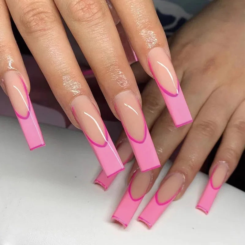 Close-up of hands with pink and clear nail design on a white background