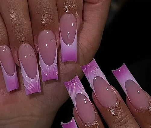French tip nail wraps shown applied to fingernails on a hand, alongside a sheet of the individual nail wrap pieces. The design features a glossy pink-to-purple gradient with white marble accents.