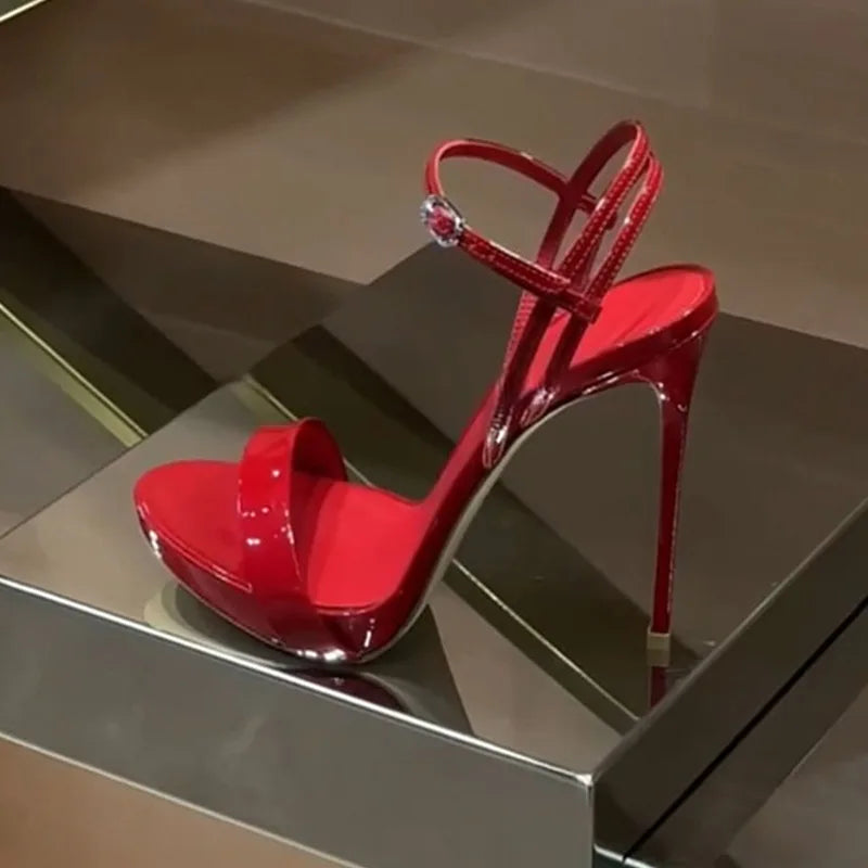 Glossy red high heels with open toe, adjustable ankle strap, and raised platform