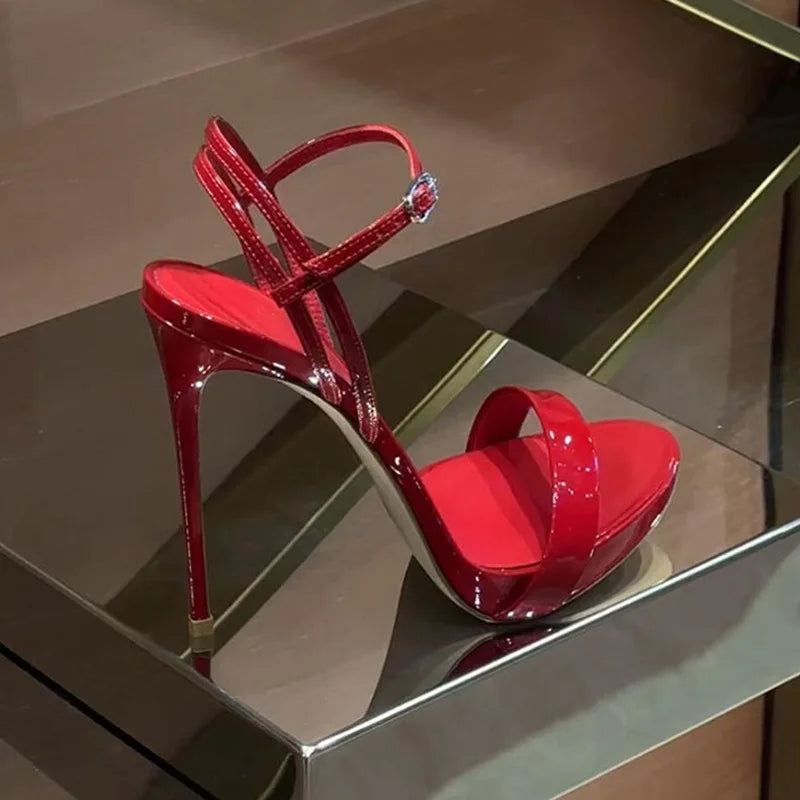 Glossy red high heels with open toe, adjustable ankle strap, and raised platform