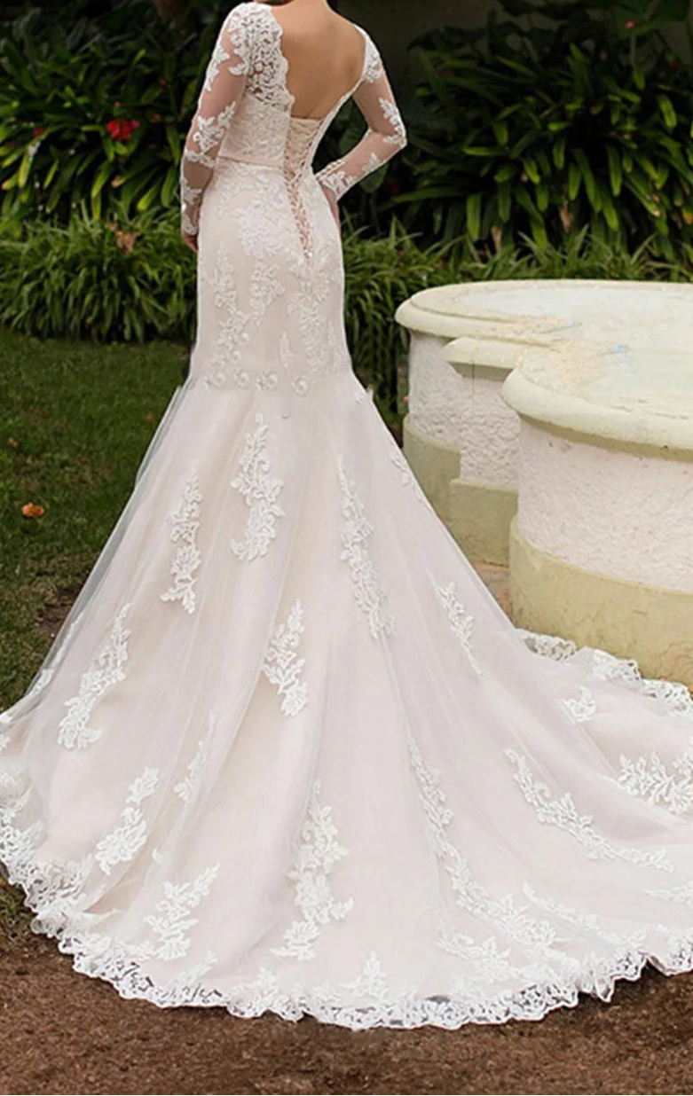 White lace wedding dress with open backless design, long sheer sleeves, and cathedral train, back view outdoors
